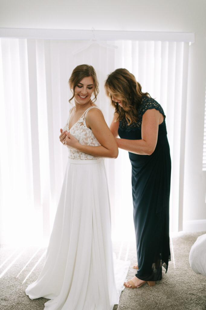 Nicole gets help from her mom in putting her dress on 