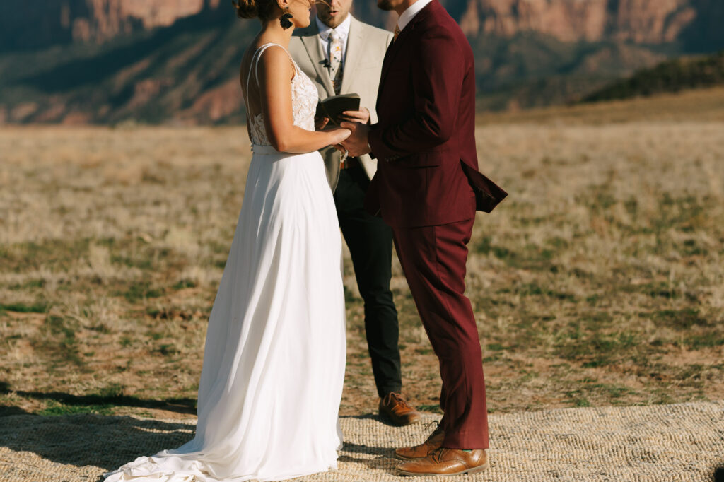 Kaleb and Nicole hold hands at the front of the aisle or their  Zion National Park elopement