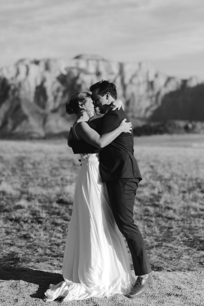 Kaleb and Nicole embrace during their first dance with Zion National Park in the back