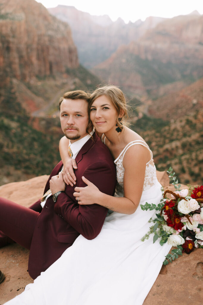 Nicole leans on Kaleb as they sit on a cliff in Zion National Park