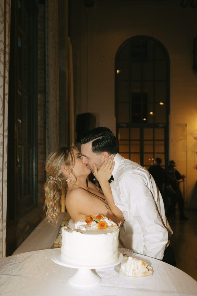 The couple kiss after a cake cut