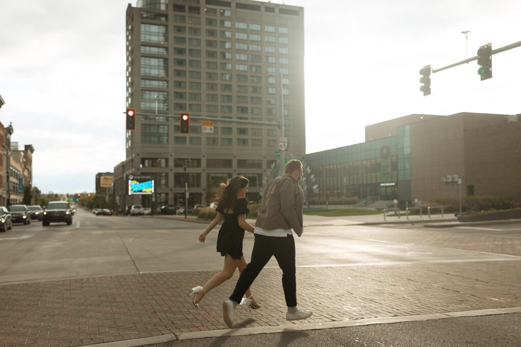 Couple crosses the street for their Downtown Toledo engagement photos