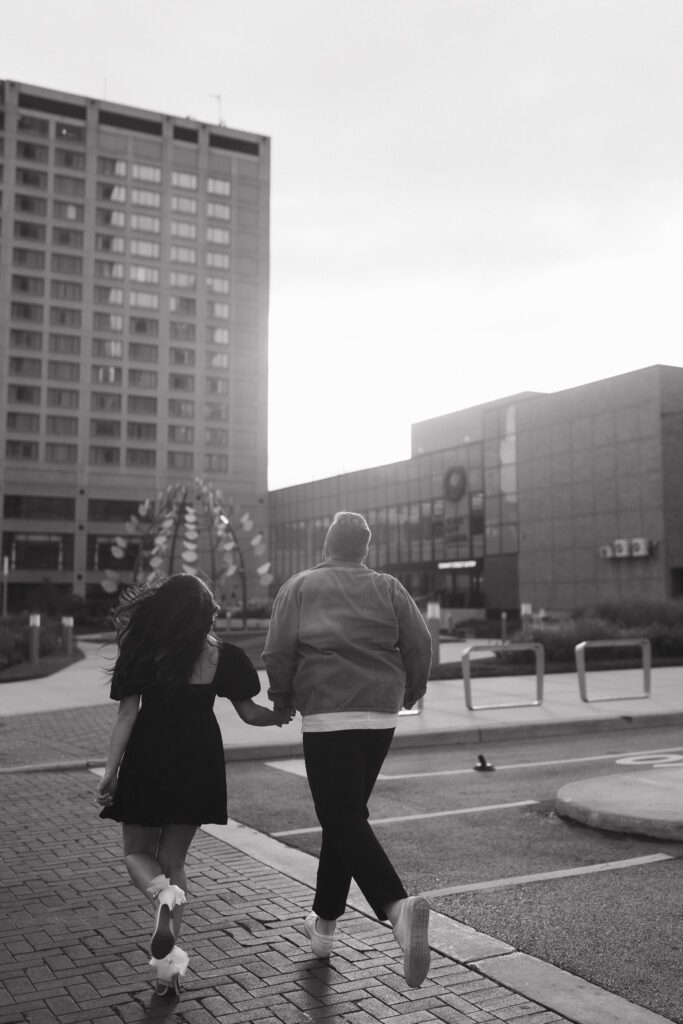 Couple crosses the street for their Downtown Toledo engagement photos