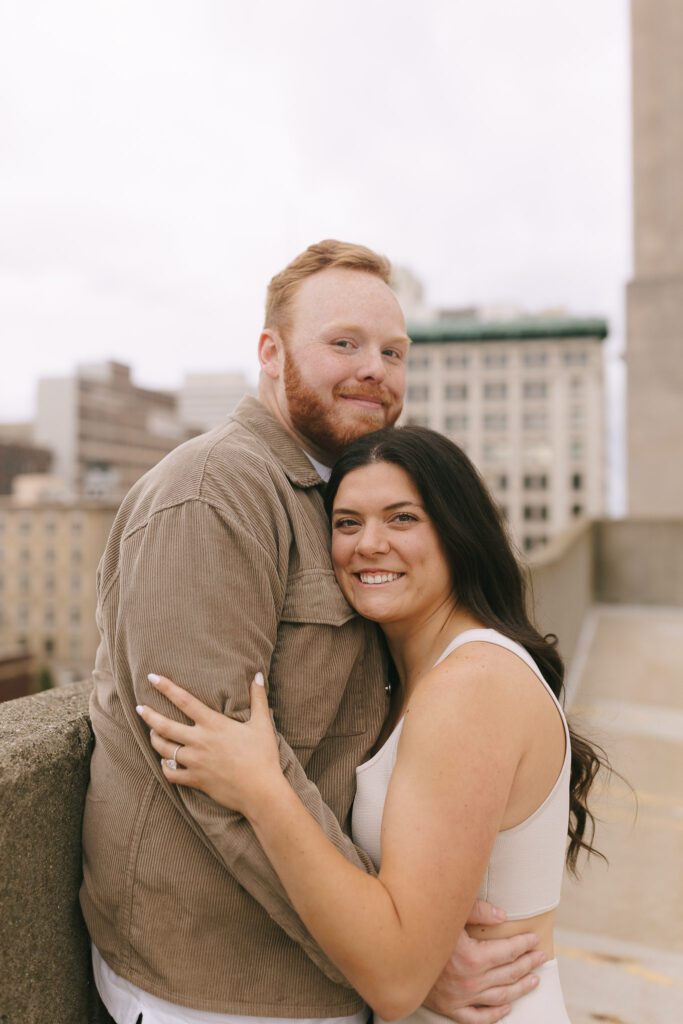 Couple embraces on rooftop for their Downtown Toledo engagement photos
