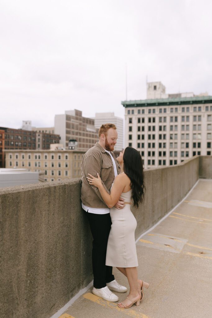 Couple stands on rooftop for their Downtown Toledo engagement photos