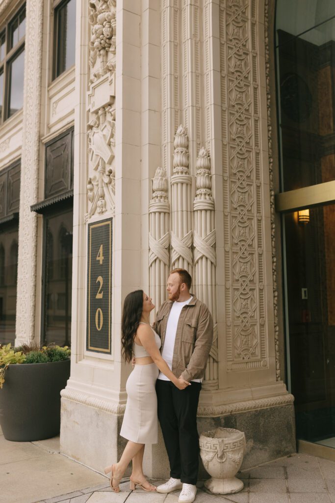 Couple stands in front of building for their Downtown Toledo engagement photos