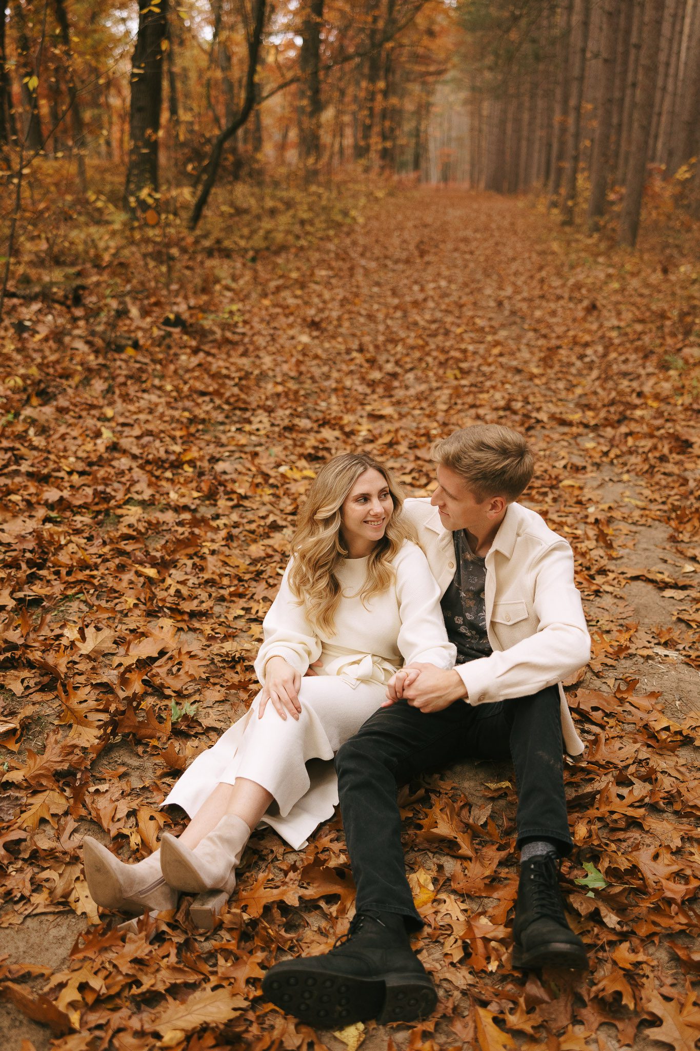 Sophia and Brad sit in the leaves 