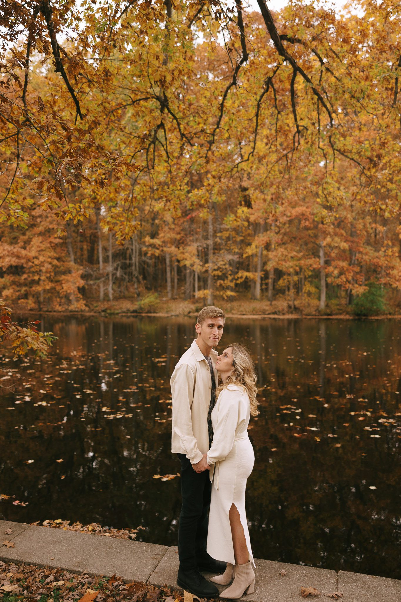 Sophia and Brad embrace by the lake 