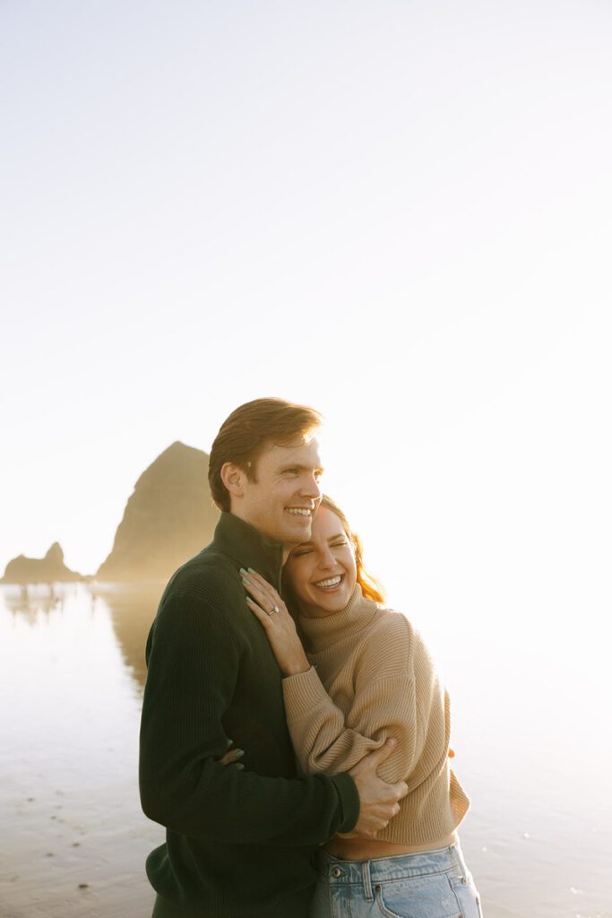 J&L embrace on the beach for their engagement photos