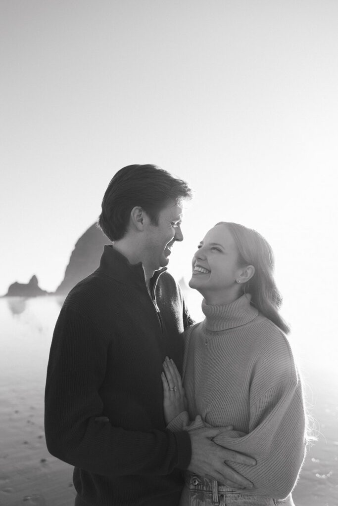 J&L embrace on the beach for their engagement photos