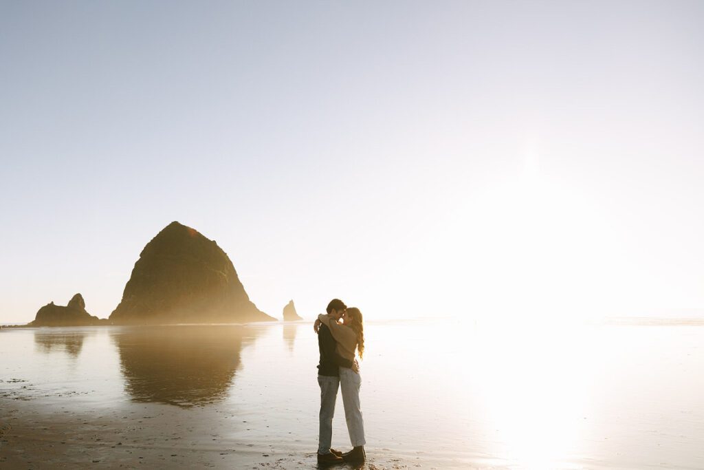 J&L embrace on the beach for their engagement photos