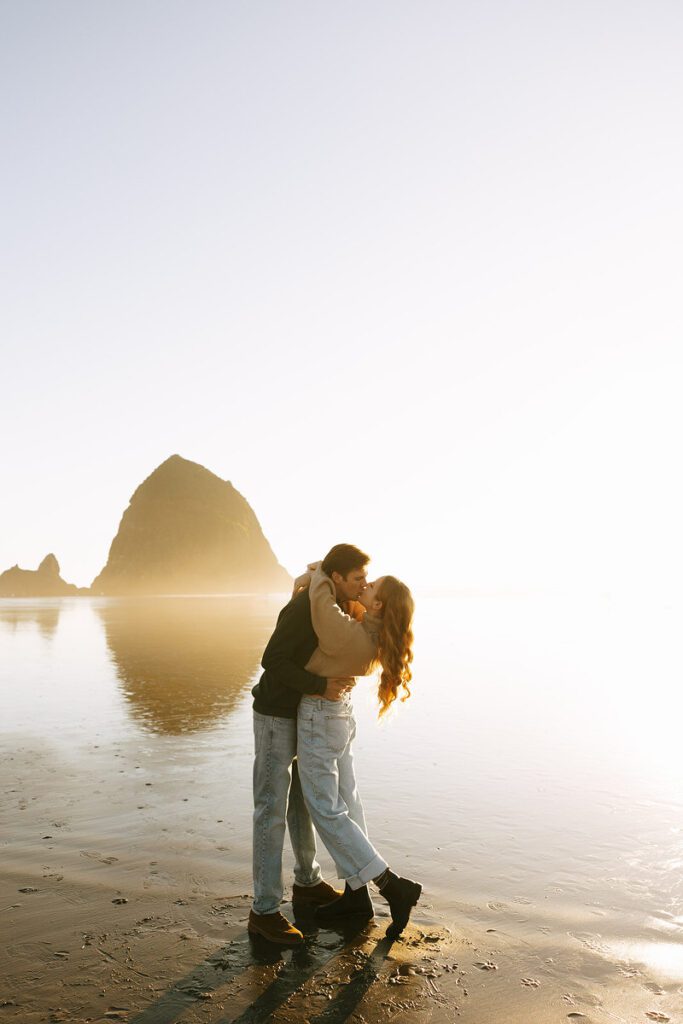 J&L embrace and kiss on the beach for their engagement photos