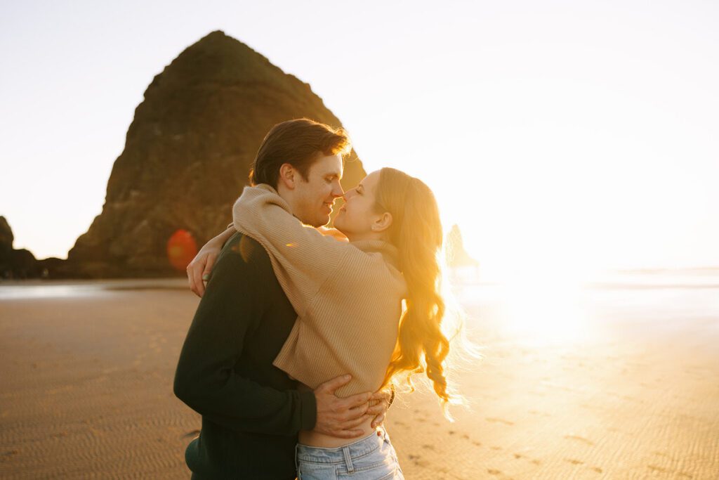 J&L embrace on the beach for their engagement photos