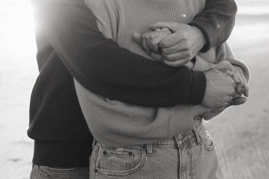 Jason and Leah embrace on the beach