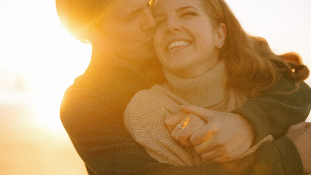 Jason and Leah embrace on the beach