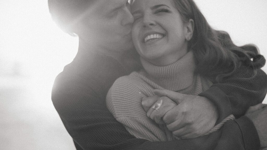 Jason and Leah embrace on the beach