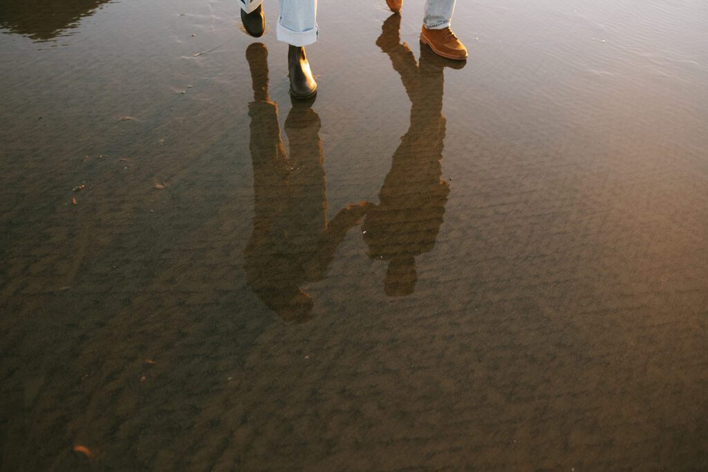 A reflection of Jason and Leah walking down the shore