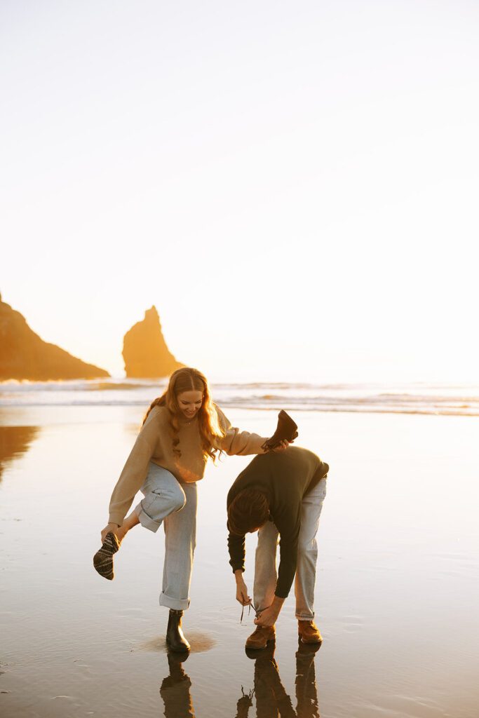 Jason and Leah take off their shoes so they walk through the surf