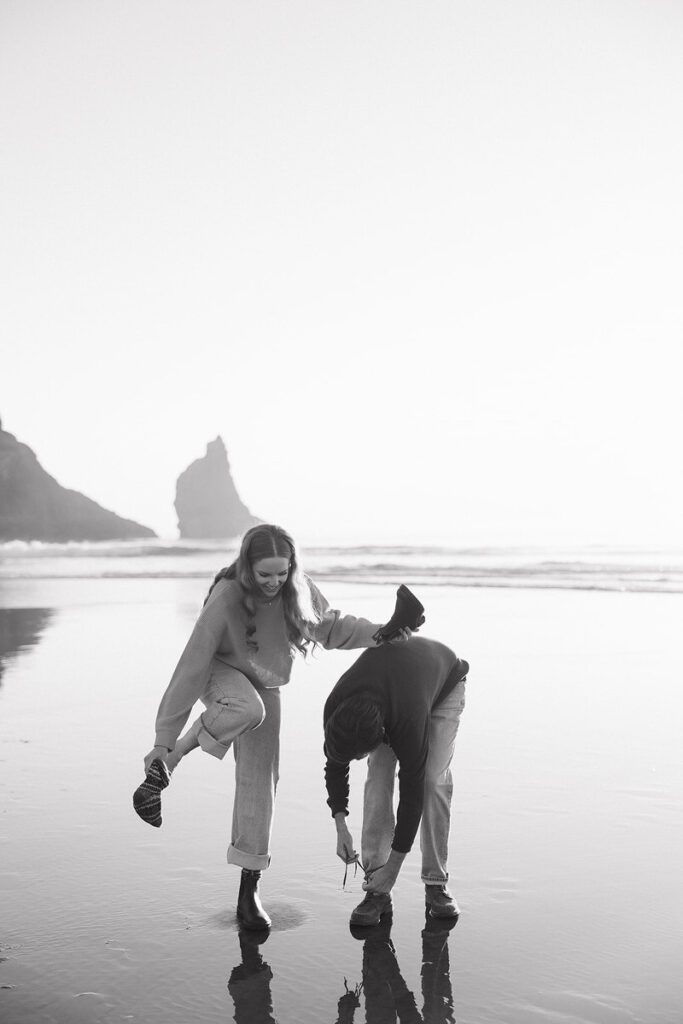 Jason and Leah take off their shoes so they walk through the surf