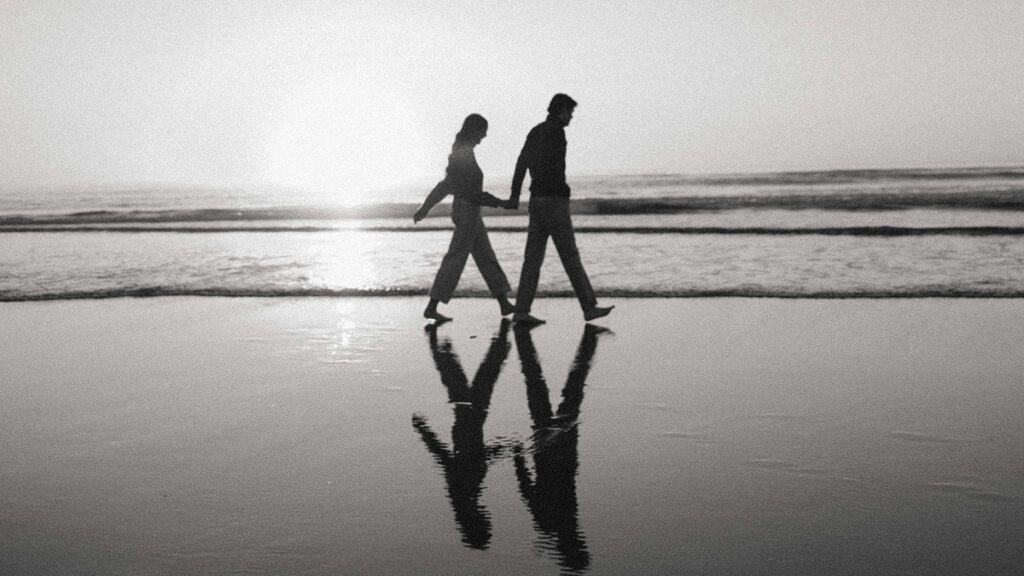 Jason and Leah walk down the shore of the Oregon coast