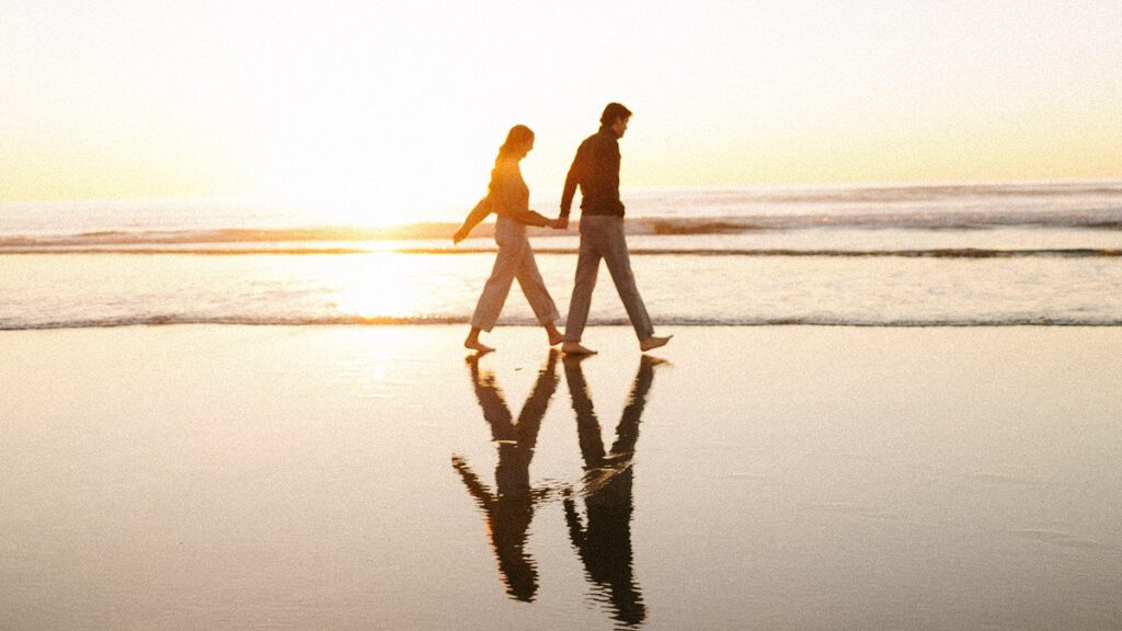 Jason and Leah walk down the shore of the Oregon coast