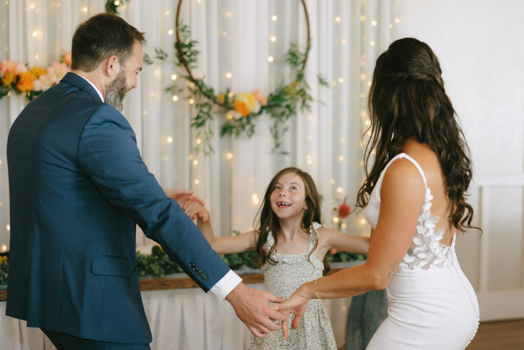 Karis and Tony invite Karis's daughter into the first dance at their reception at Bloom and Bower, an Ohio wedding venue