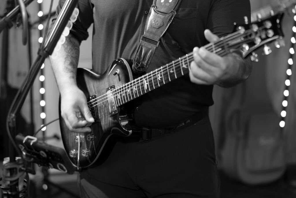 A close up of the guitar player of the live musical act at Bloom and Bower, an Ohio wedding venue