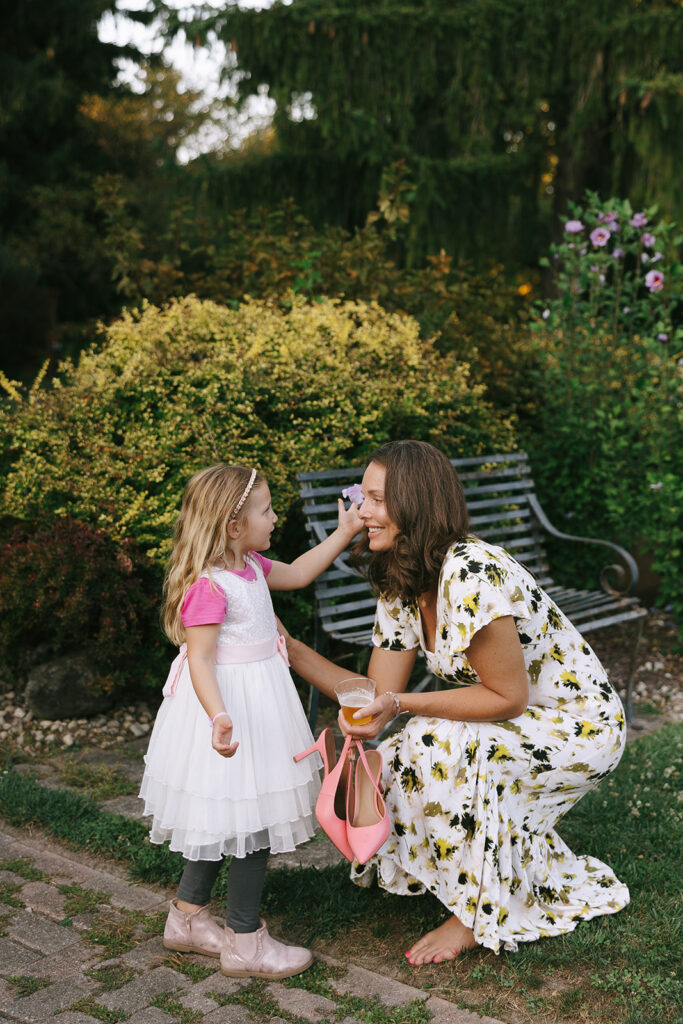 A child puts a flower in another guests hair at this wildflower themed wedding at Bloom and Bower