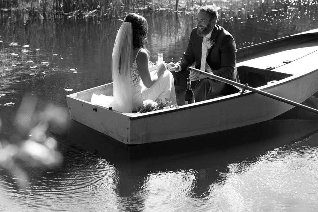 The couple rides in a canoe shortly after their ceremony, sharing a moment with a champagne  toast