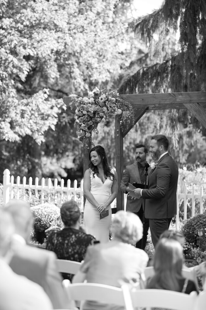 Karis looks over at her daughter as Tony says his vows to her too, during their wedding at Bloom and Bower