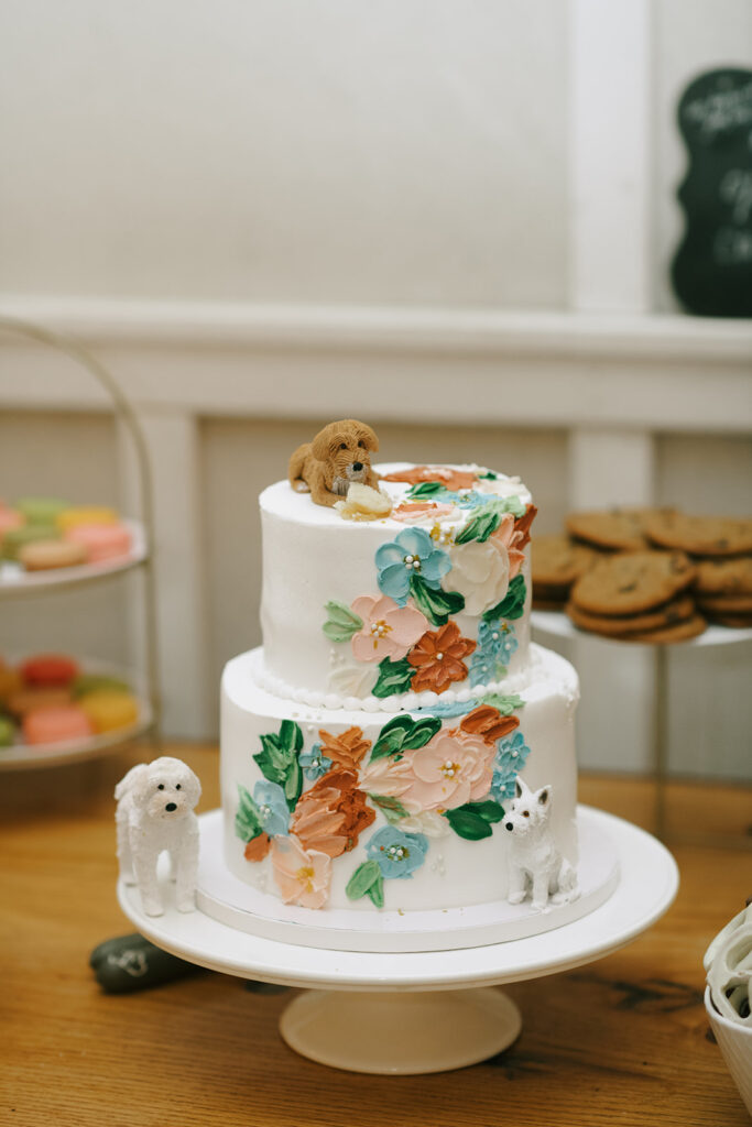 The married couples cake, adorned with wildflowers and statues of their dogs