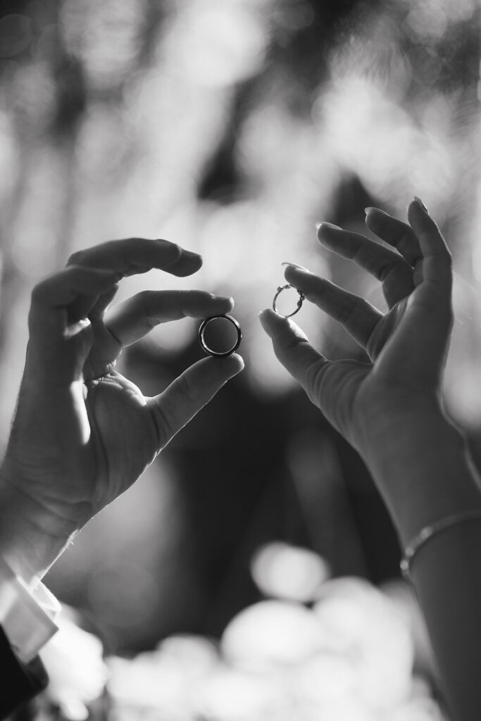 Karis and Tony hold their rings up in the sun after their wedding at Bloom and Bower