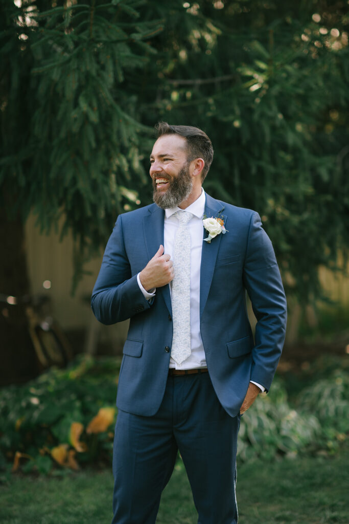 Tony looks off into the distance, holding the lapel of his suit