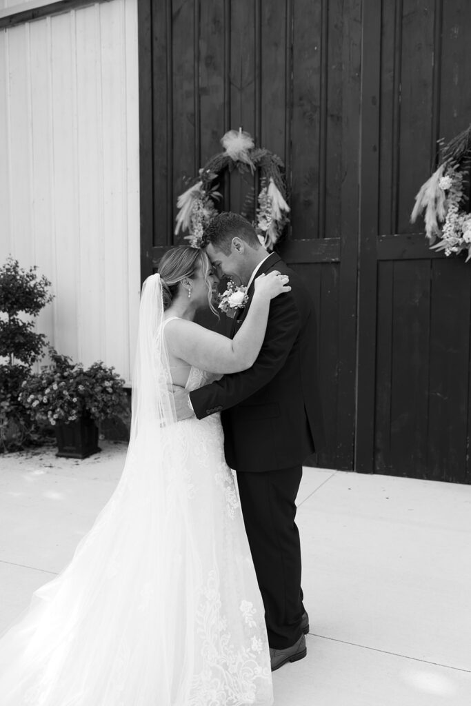 Bride and groom embracing each other in a tender moment, forehead-to-forehead