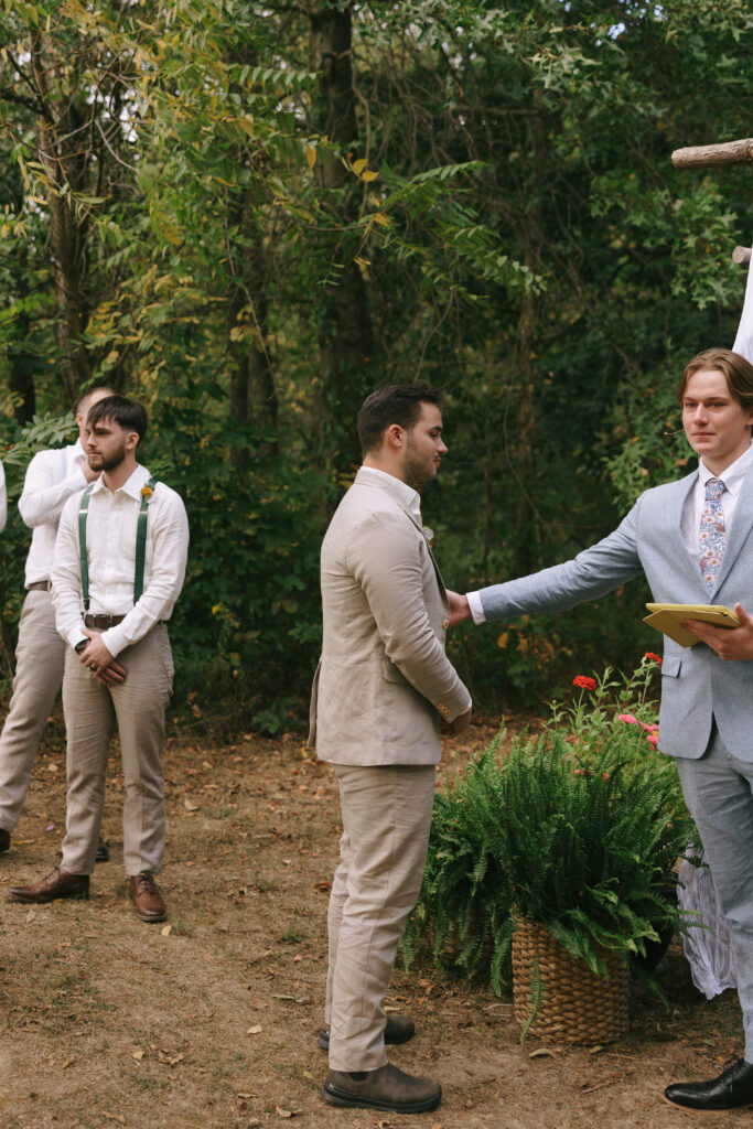 Groom being tapped to look at bride