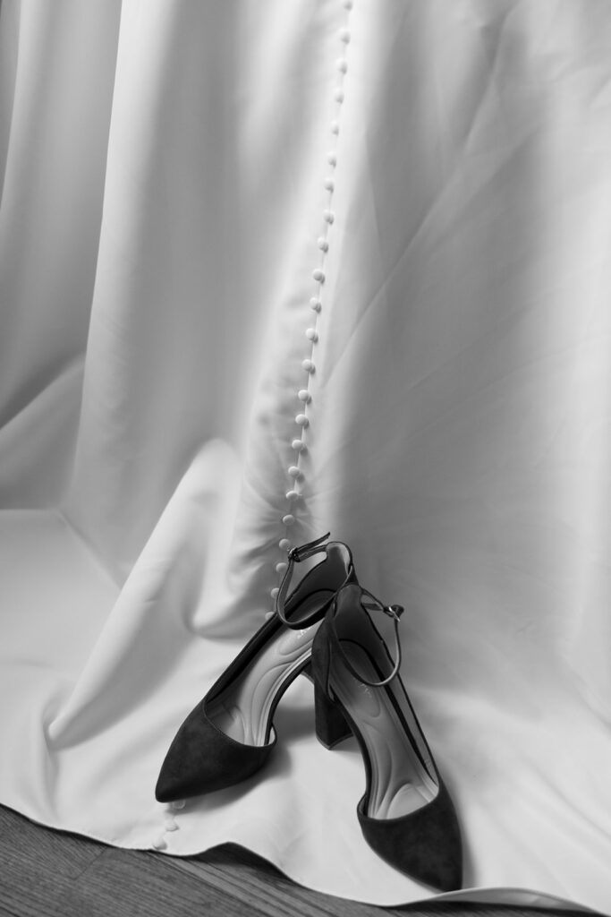 black and white photo of wedding dress and heels