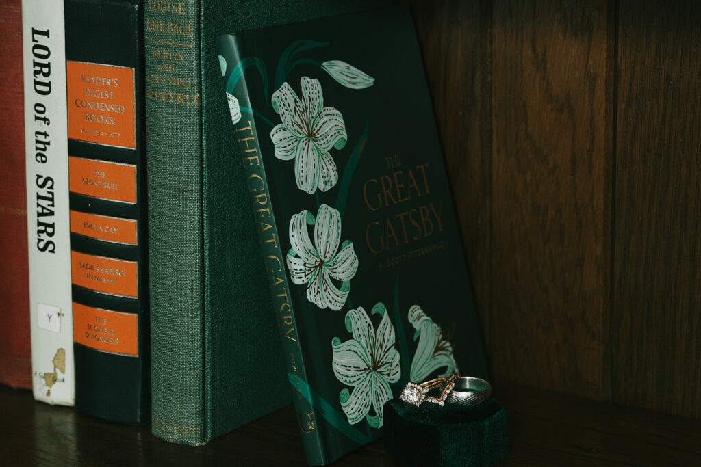 wedding detail photos with rings and forest green books matching the wedding theme