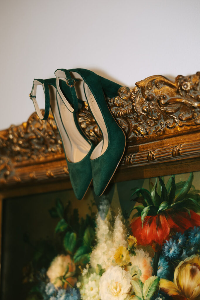 Wedding day detail shots with green high shoes and painting at wedding venue