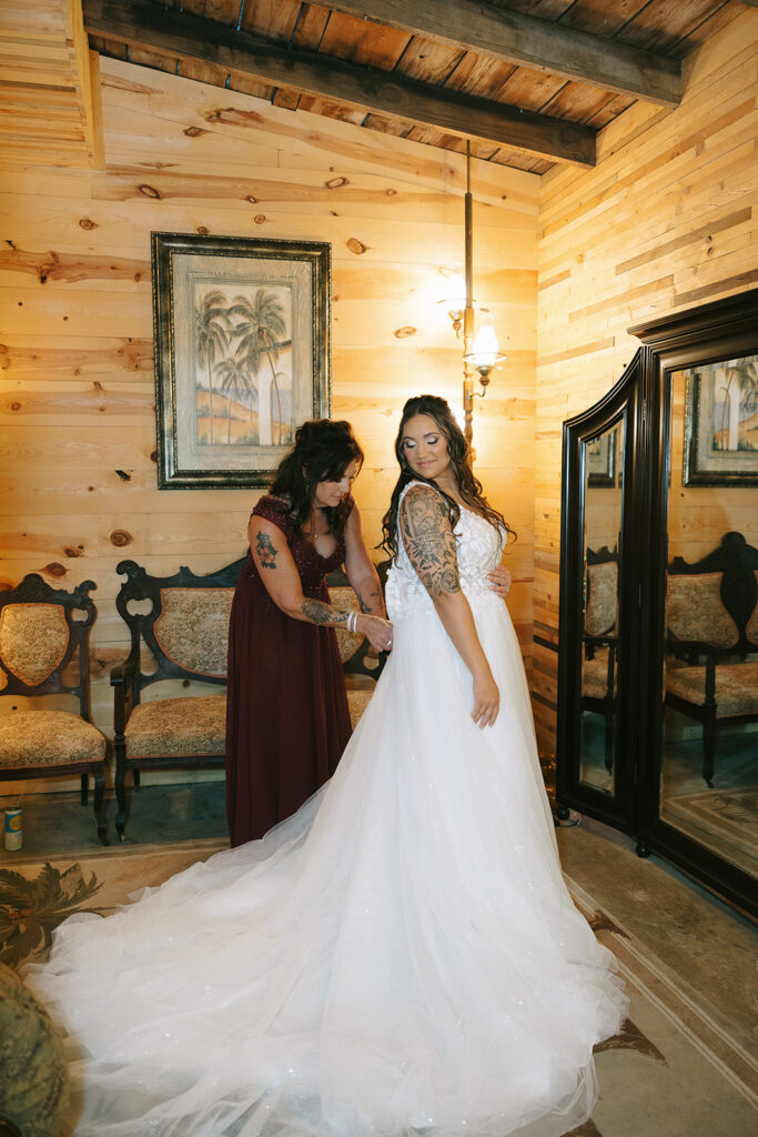 Bride getting her dress zipped on her wedding day