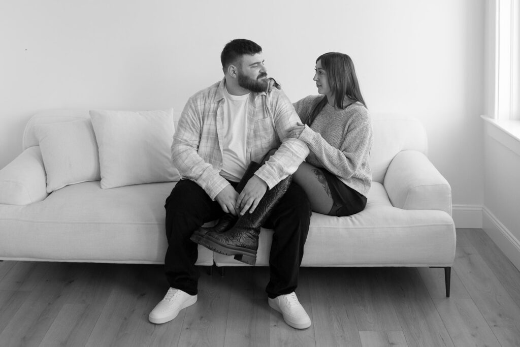Black and white close-up of an engaged couple holding hands, showcasing the engagement ring symbolizing the first step in wedding planning.