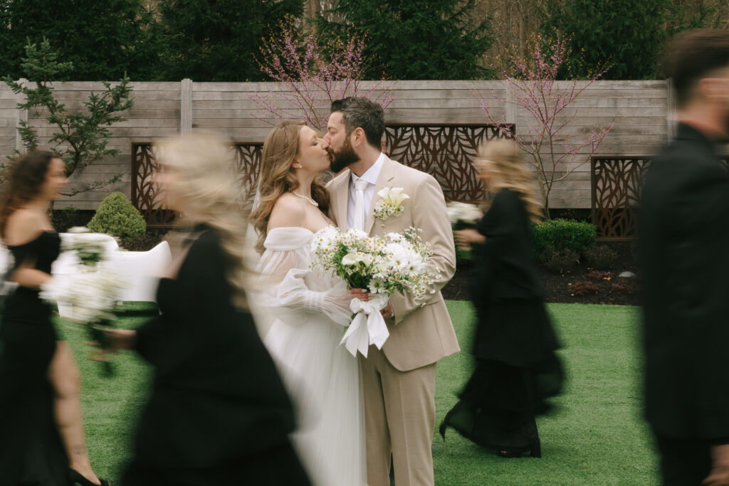 Bride and groom laughing during their ceremony with a wedding coordinator in the background ensuring everything runs smoothly