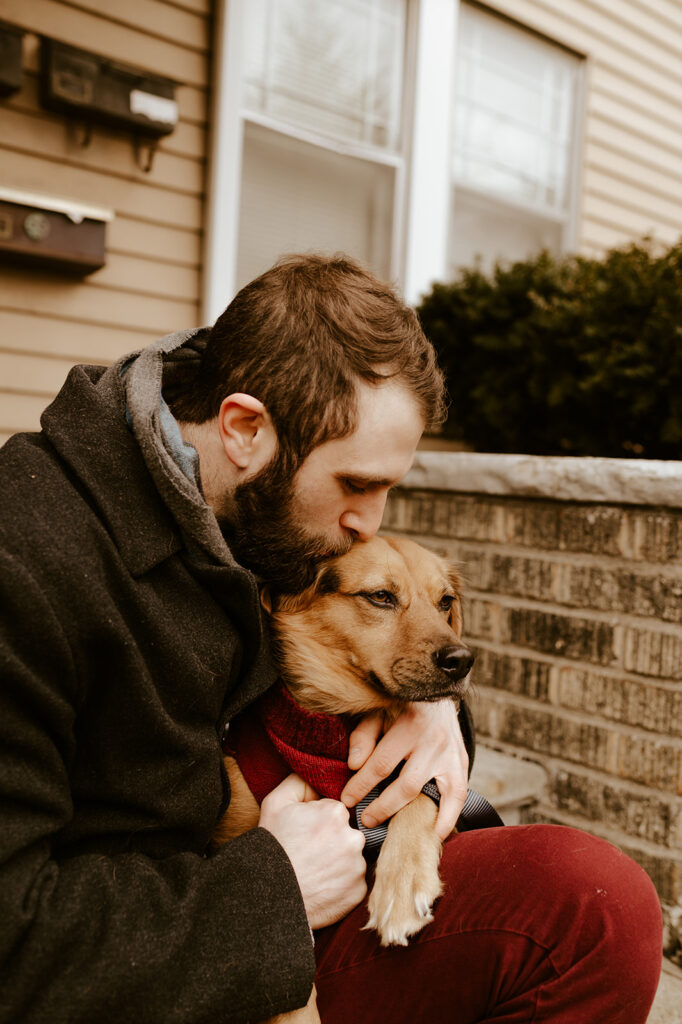 Man holding his dog at his engagement session 