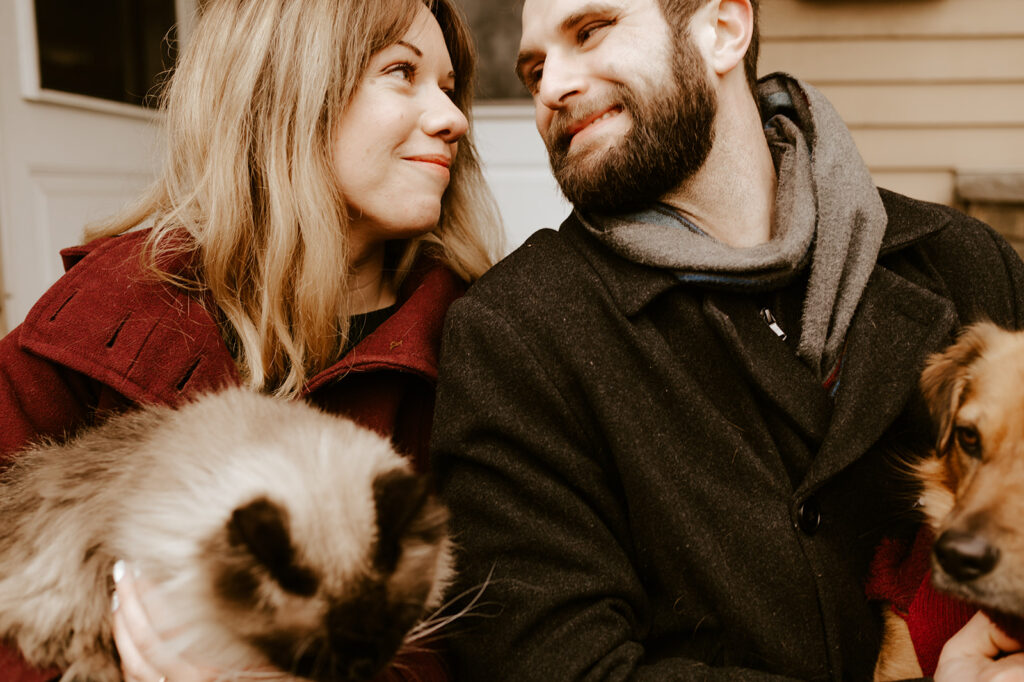 Engaged couple walking hand-in-hand with their dog on a leash, including their dog in engagement photos