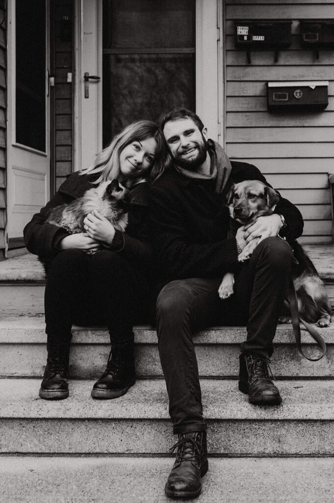A couple holding their pets at their engagement session 