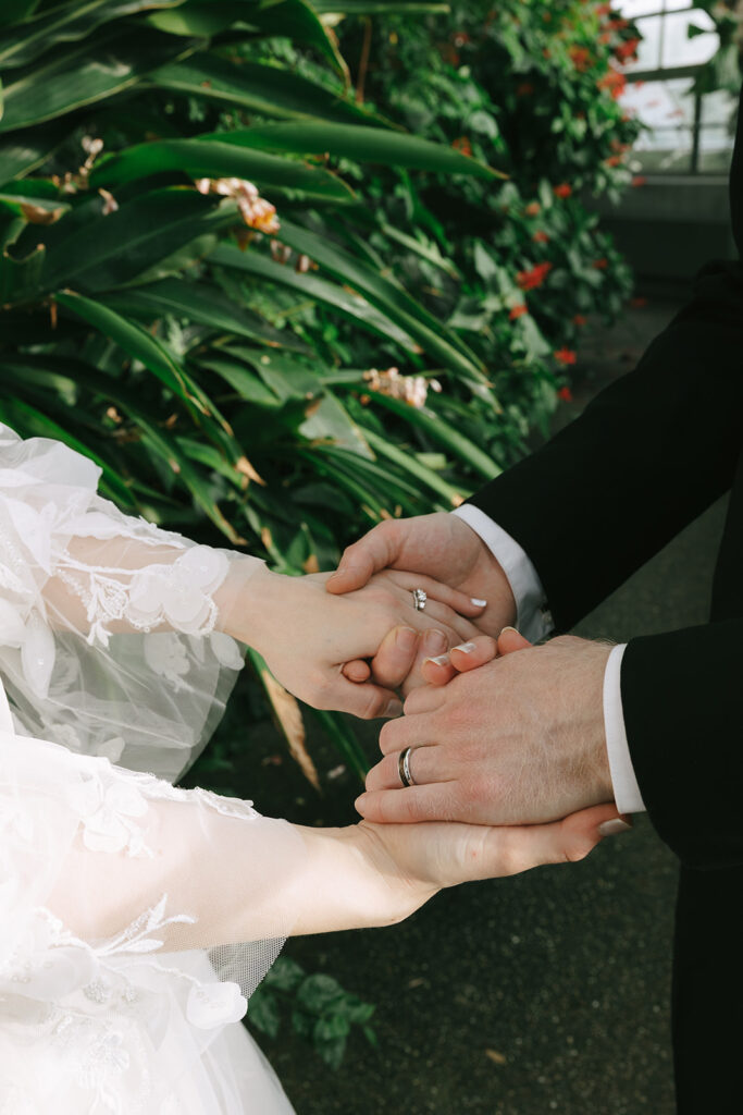 Close-up of a couple holding hands, grounding each other before the wedding

