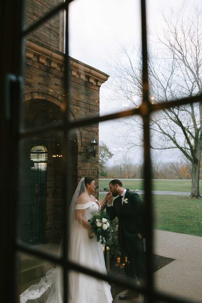 Bride looking up at her groom outside a historic brick venue, natural moment captured that couples expect when finding a wedding photographer on Instagram.