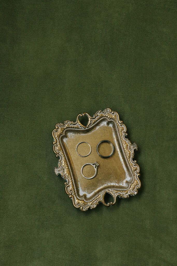 wedding day timeline details featuring wedding rings displayed on an antique gold tray