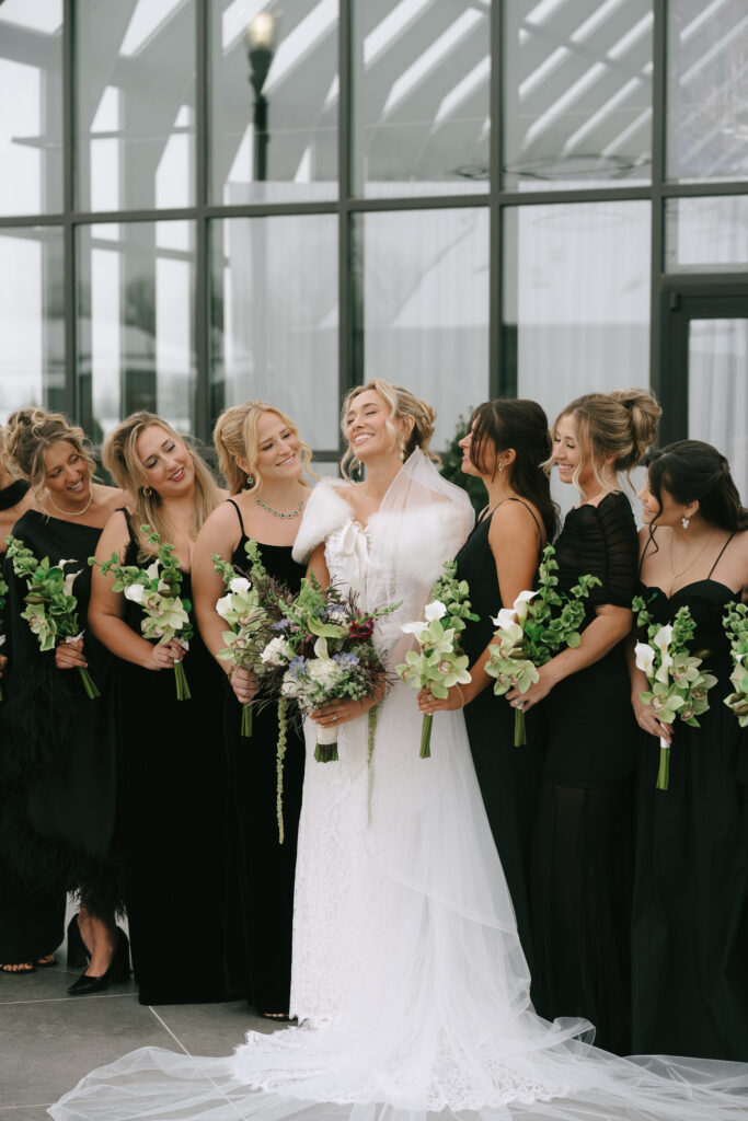 Bride in the middle with bridesmaids around her. All of the women are holding bouquets.