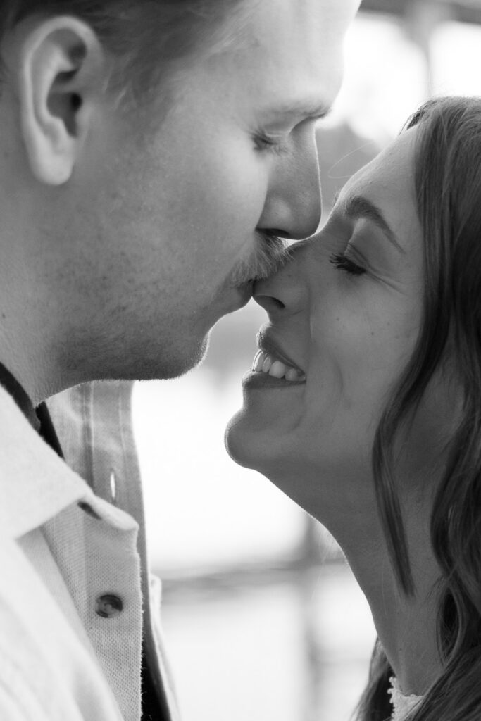 Close up of man kissing woman on the nose during their engagement photos for camera-shy couples.