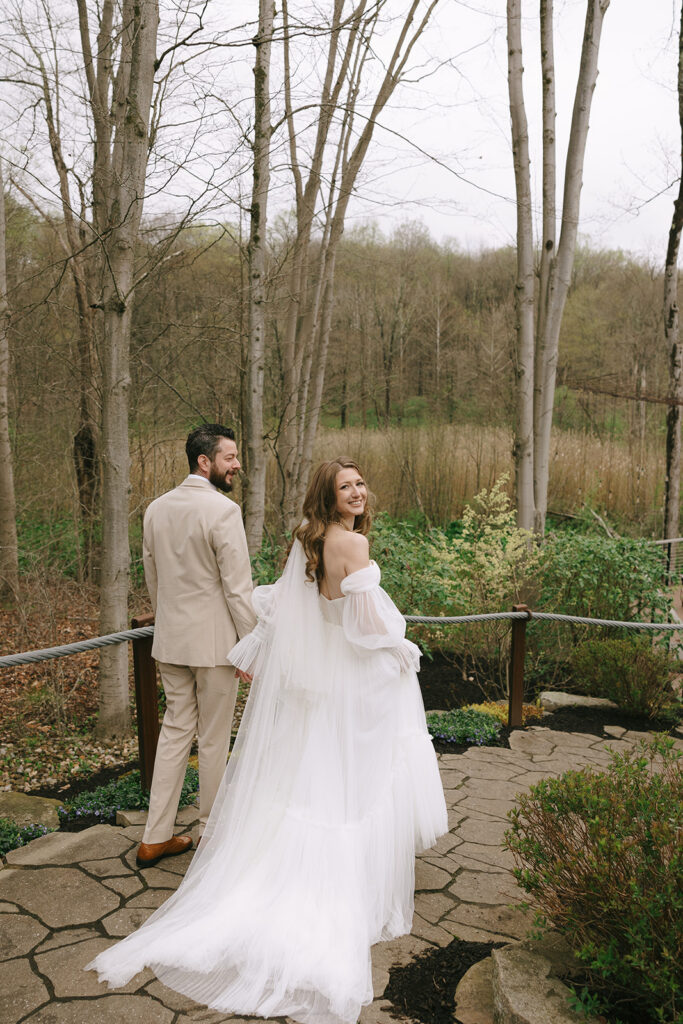 Partners walking together with woods behind them and protecting their wedding day energy.